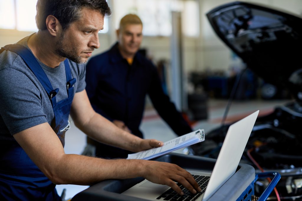 Automotive technician using the iCarsoft VAWS V4.0 diagnostic scanner for advanced VAG vehicle diagnostics